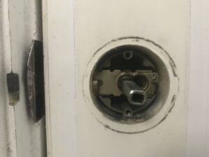 A damaged residential door lock symbolizing weak home security.